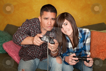 To use this stock image in your creative project, please select the size you need over to the right and click the "Add to Cart" button.
Your downloaded image will come with the Cutcaster watermark removed so don’t worry about the watermark you see on this page. Hispanic Man and Girl Playing Video game stock photo, Attractive Hispanic Man and Girl Playing a Video Game with Handheld Controllers by Scott Griessel