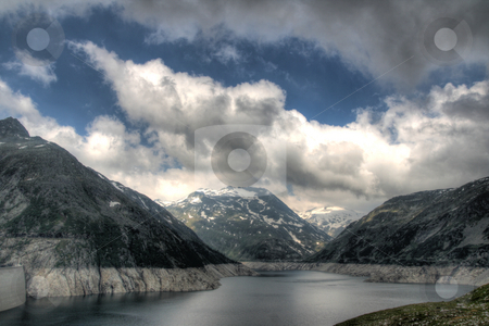 To use this stock image in your creative project, please select the size you need over to the right and click the "Add to Cart" button.
Your downloaded image will come with the Cutcaster watermark removed so don’t worry about the watermark you see on this page. Alps mountains and lake stock photo, View of alps mountains with snow and lake under dramatic sky in very early morning by Daniel Oertelt