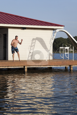 To use this stock image in your creative project, please select the size you need over to the right and click the "Add to Cart" button.
Your downloaded image will come with the Cutcaster watermark removed so don’t worry about the watermark you see on this page. Dock Man stock photo, A man is doing a back flip off the end of a dock into the water by Kevin Tietz