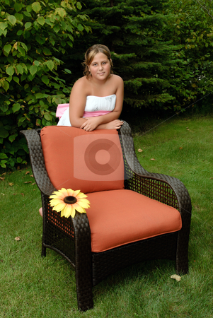 To use this stock image in your creative project, please select the size you need over to the right and click the "Add to Cart" button.
Your downloaded image will come with the Cutcaster watermark removed so don’t worry about the watermark you see on this page. Girl Relaxing In The Sun stock photo, A cute young girl, wearing a white dress is relaxing in the sun whilte leaning on a wicker chair outside. by Richard Nelson