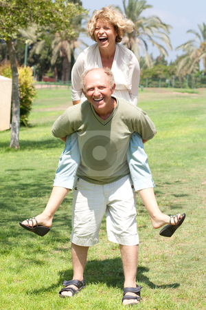 To use this stock image in your creative project, please select the size you need over to the right and click the "Add to Cart" button.
Your downloaded image will come with the Cutcaster watermark removed so don’t worry about the watermark you see on this page. Image of Senior man giving woman piggyback ride stock photo, Happy active senior man giving woman piggyback ride by Get4net