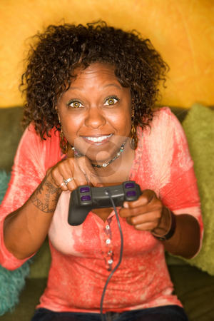 To use this stock image in your creative project, please select the size you need over to the right and click the "Add to Cart" button.
Your downloaded image will come with the Cutcaster watermark removed so don’t worry about the watermark you see on this page. African-American woman plays video game stock photo, Attractive woman plays video game with hand held controller by Scott Griessel