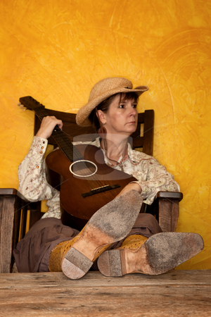 To use this stock image in your creative project, please select the size you need over to the right and click the "Add to Cart" button.
Your downloaded image will come with the Cutcaster watermark removed so don’t worry about the watermark you see on this page. Pretty Western Woman with Guitar stock photo, Pretty western woman in antique rocking chair with guitar by Scott Griessel