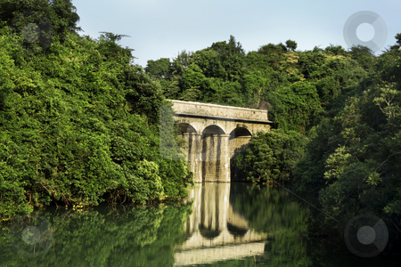 To use this stock image in your creative project, please select the size you need over to the right and click the "Add to Cart" button.
Your downloaded image will come with the Cutcaster watermark removed so don’t worry about the watermark you see on this page. Ancient roman bridge stock photo, Ancient roman bridge in the forest on the lake by Keng po Leung