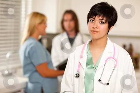To use this stock image in your creative project, please select the size you need over to the right and click the "Add to Cart" button.
Your downloaded image will come with the Cutcaster watermark removed so don’t worry about the watermark you see on this page. Pretty Latino Doctor Smiles at Camera as Colleagues Talk stock photo, Pretty Latino Doctor Smiles at the Camera as Colleagues Talk Behind Her. by Andy Dean