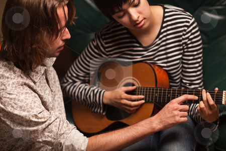 To use this stock image in your creative project, please select the size you need over to the right and click the "Add to Cart" button.
Your downloaded image will come with the Cutcaster watermark removed so don’t worry about the watermark you see on this page. Young Musician Teaches Female Student To Play the Guitar stock photo, Young Male Musician Teaches Female Student How To Play the Guitar. by Andy Dean