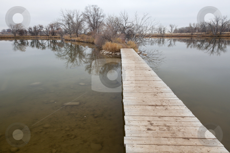 To use this stock image in your creative project, please select the size you need over to the right and click the "Add to Cart" button.
Your downloaded image will come with the Cutcaster watermark removed so don’t worry about the watermark you see on this page. Boardwalk pathway over lake and swamp stock photo, Nature trail - boardwalk pathway over lake in old gravel quarry converted into park (Riverbend Ponds in Fort Collins, Colorado), late fall nostalgic scenery by Marek Uliasz