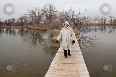 To use this stock image in your creative project, please select the size you need over to the right and click the "Add to Cart" button.
Your downloaded image will come with the Cutcaster watermark removed so don’t worry about the watermark you see on this page. Senior woman enjoys a walki alone stock photo, Senior woman in her eighties walking alone on a footbridge across lake, nostalgic late fall scenery, life pathway metaphor by Marek Uliasz