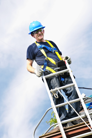 To use this stock image in your creative project, please select the size you need over to the right and click the "Add to Cart" button.
Your downloaded image will come with the Cutcaster watermark removed so don’t worry about the watermark you see on this page. Man working on roof stock photo, Construction worker standing on roof near ladder by Elena Elisseeva