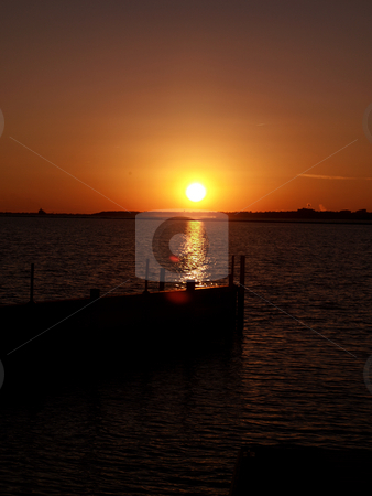 To use this stock image in your creative project, please select the size you need over to the right and click the "Add to Cart" button.
Your downloaded image will come with the Cutcaster watermark removed so don’t worry about the watermark you see on this page. Golden sunset stock photo, The North Carolina Coast shown at night along the docks by Tim Markley
