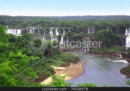 To use this stock image in your creative project, please select the size you need over to the right and click the "Add to Cart" button.
Your downloaded image will come with the Cutcaster watermark removed so don’t worry about the watermark you see on this page. Iguassu waterfall, Iguazu waterfall stock photo, The Iguassu (or Iguazu) Falls is one of the largest masses of fresh water on the planet and divides, in South America, Brazil, Paraguay and Argentina. The waterfall system consists of 275 falls along 2.7 kilometres (1.67 miles) of the Iguazu River. Some of the individual falls are up to 82 metres (269 feet) in height, though the majority are about 64 metres (210 feet). by Daniel Wiedemann