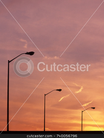 To use this stock image in your creative project, please select the size you need over to the right and click the "Add to Cart" button.
Your downloaded image will come with the Cutcaster watermark removed so don’t worry about the watermark you see on this page. Street Lights stock photo, Street lights at sunset. by Kathy Piper