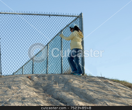 To use this stock image in your creative project, please select the size you need over to the right and click the "Add to Cart" button.
Your downloaded image will come with the Cutcaster watermark removed so don’t worry about the watermark you see on this page. Escape stock photo, A young girl standing at the top of a security hill near the fence, trying to escape by Richard Nelson