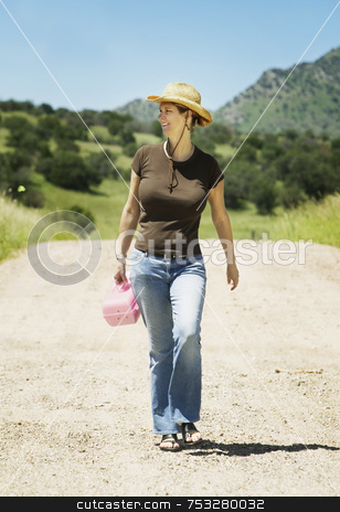 To use this stock image in your creative project, please select the size you need over to the right and click the "Add to Cart" button.
Your downloaded image will come with the Cutcaster watermark removed so don’t worry about the watermark you see on this page. Woman on a Country Road stock photo, Woman in a cowboy hat and casual clothes walking down a country road by Scott Griessel