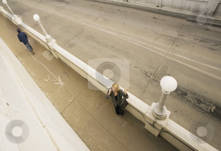 To use this stock image in your creative project, please select the size you need over to the right and click the "Add to Cart" button.
Your downloaded image will come with the Cutcaster watermark removed so don’t worry about the watermark you see on this page. Looking Down on a Woman on Her Cell Phone stock photo, Wide shot from above of woman on her cell phone next to an empty road. by Scott Griessel