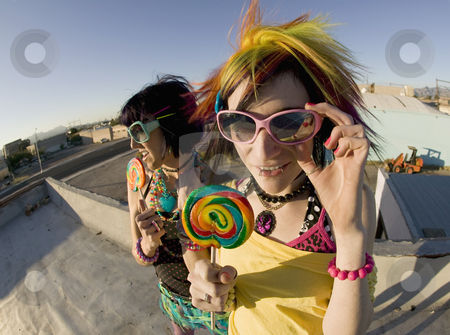 To use this stock image in your creative project, please select the size you need over to the right and click the "Add to Cart" button.
Your downloaded image will come with the Cutcaster watermark removed so don’t worry about the watermark you see on this page. Fun girls on the roof with lollipops stock photo, Fisheye shot of girls in brightly colored clothing on a roof with sunglasses and lollipops by Scott Griessel