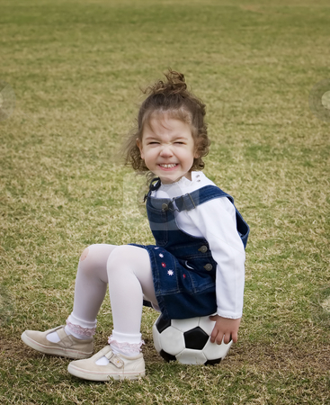 To use this stock image in your creative project, please select the size you need over to the right and click the "Add to Cart" button.
Your downloaded image will come with the Cutcaster watermark removed so don’t worry about the watermark you see on this page. Little girl sitting on a soccer ball. stock photo, Little girl on a playground sitting on a soccer ball and making a funny face. by Scott Griessel