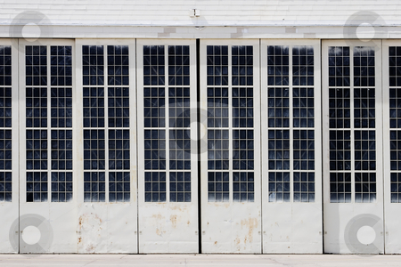 To use this stock image in your creative project, please select the size you need over to the right and click the "Add to Cart" button.
Your downloaded image will come with the Cutcaster watermark removed so don’t worry about the watermark you see on this page. White Hangar stock photo, White airport hangar. by Scott Griessel