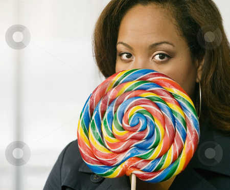 To use this stock image in your creative project, please select the size you need over to the right and click the "Add to Cart" button.
Your downloaded image will come with the Cutcaster watermark removed so don’t worry about the watermark you see on this page. Woman Peeking Out From Behind A Lollipop stock photo, African-American woman stares from behind a colorful lollipop by Scott Griessel