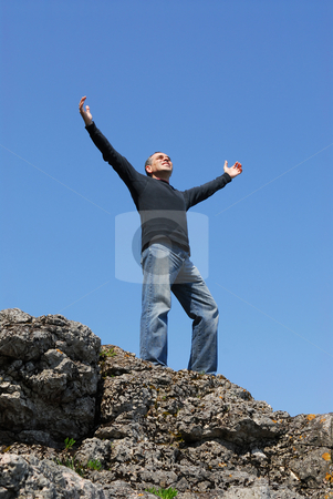To use this stock image in your creative project, please select the size you need over to the right and click the "Add to Cart" button.
Your downloaded image will come with the Cutcaster watermark removed so don’t worry about the watermark you see on this page. Carefree man stock photo, A man standing on a cliff with his arms raised to the blue sky by Elena Elisseeva