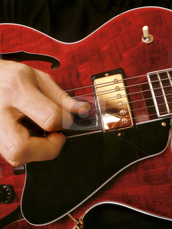 To use this stock image in your creative project, please select the size you need over to the right and click the "Add to Cart" button.
Your downloaded image will come with the Cutcaster watermark removed so don’t worry about the watermark you see on this page. Electric guitar playing stock photo, Close-up of a jazz musician playing red electric guitar. by © Ron Sumners