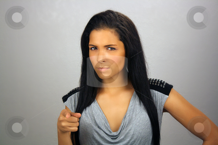 To use this stock image in your creative project, please select the size you need over to the right and click the "Add to Cart" button.
Your downloaded image will come with the Cutcaster watermark removed so don’t worry about the watermark you see on this page. Beautiful but Serious Teen Latina stock photo, A lovely but serious teenage Latina points her right index finger at you. by Carl Stewart