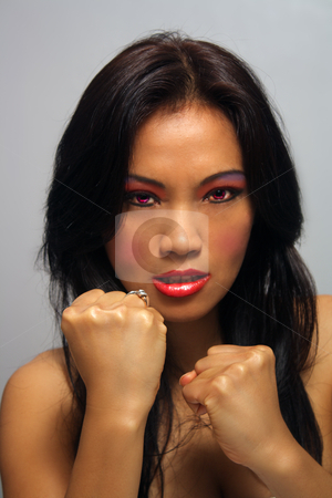 To use this stock image in your creative project, please select the size you need over to the right and click the "Add to Cart" button.
Your downloaded image will come with the Cutcaster watermark removed so don’t worry about the watermark you see on this page. Beautiful Angry Asian Girl with Fists stock photo, A lovely young Indonesial model with long, luscious black hair holds her fists up ready to fight. Her glowing red eyes match her firey persona. by Carl Stewart