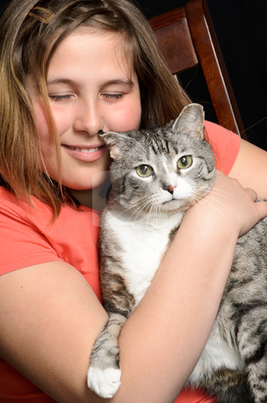 To use this stock image in your creative project, please select the size you need over to the right and click the "Add to Cart" button.
Your downloaded image will come with the Cutcaster watermark removed so don’t worry about the watermark you see on this page. Pet Love stock photo, A young girl holding her pet cat, while sitting on a chair, isolated against a black background. by Richard Nelson