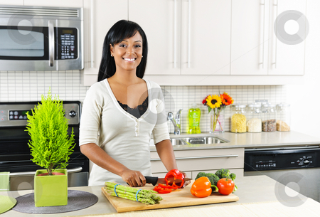 To use this stock image in your creative project, please select the size you need over to the right and click the "Add to Cart" button.
Your downloaded image will come with the Cutcaster watermark removed so don’t worry about the watermark you see on this page. Young woman cutting vegetables in kitchen stock photo, Smiling black woman cutting vegetables in modern kitchen interior by Elena Elisseeva