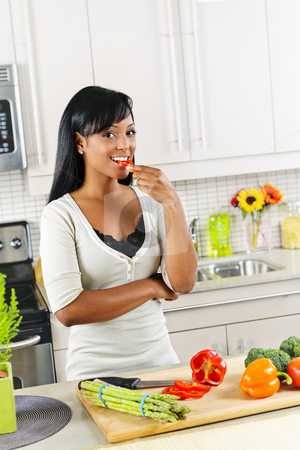 To use this stock image in your creative project, please select the size you need over to the right and click the "Add to Cart" button.
Your downloaded image will come with the Cutcaster watermark removed so don’t worry about the watermark you see on this page. Young woman tasting vegetables in kitchen stock photo, Smiling black woman tasting vegetables in modern kitchen interior by Elena Elisseeva
