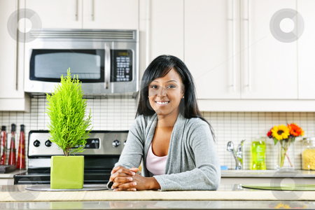 To use this stock image in your creative project, please select the size you need over to the right and click the "Add to Cart" button.
Your downloaded image will come with the Cutcaster watermark removed so don’t worry about the watermark you see on this page. Young woman in kitchen stock photo, Smiling black woman in modern kitchen interior by Elena Elisseeva