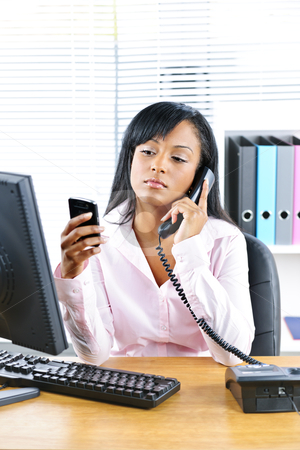 To use this stock image in your creative project, please select the size you need over to the right and click the "Add to Cart" button.
Your downloaded image will come with the Cutcaster watermark removed so don’t worry about the watermark you see on this page. Black businesswoman using two phones at desk stock photo, Young black business woman multitasking using two phones in office by Elena Elisseeva
