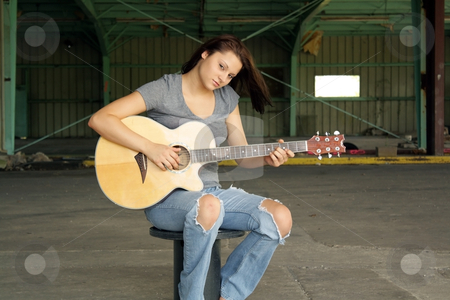 To use this stock image in your creative project, please select the size you need over to the right and click the "Add to Cart" button.
Your downloaded image will come with the Cutcaster watermark removed so don’t worry about the watermark you see on this page. Beautiful Brunette with a Guitar (4) stock photo, A lovely young brunette wearing tattered jeans, sits with her guitar at an abandoned warehouse facility. by Carl Stewart