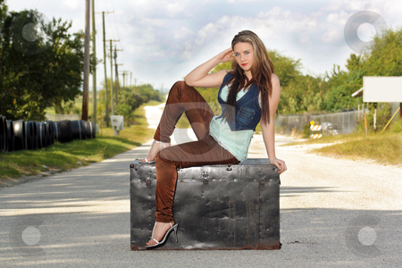 To use this stock image in your creative project, please select the size you need over to the right and click the "Add to Cart" button.
Your downloaded image will come with the Cutcaster watermark removed so don’t worry about the watermark you see on this page. Teen Girl on a Trunk in the Street (2) stock photo, A lovely teenage girl sits fashionably on an antique trunk in the middle of a lonely country road. by Carl Stewart