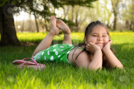 To use this stock image in your creative project, please select the size you need over to the right and click the "Add to Cart" button.
Your downloaded image will come with the Cutcaster watermark removed so don’t worry about the watermark you see on this page. Kid Relaxing Outside stock photo, A young girl laying in the grass relaxing and enjoying the spring weather. by Richard Nelson