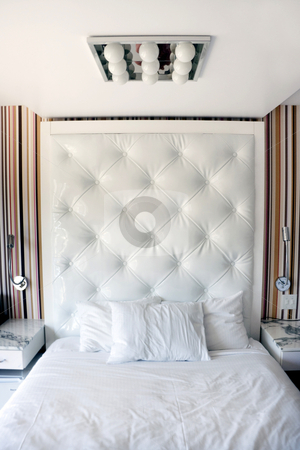 To use this stock image in your creative project, please select the size you need over to the right and click the "Add to Cart" button.
Your downloaded image will come with the Cutcaster watermark removed so don’t worry about the watermark you see on this page. White Hotel Bedroom stock photo, A modern white hotel bedroom with night stand by Kevin Tietz