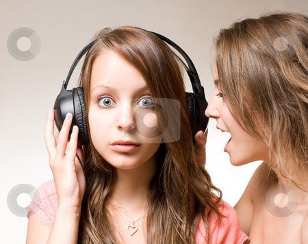 To use this stock image in your creative project, please select the size you need over to the right and click the "Add to Cart" button.
Your downloaded image will come with the Cutcaster watermark removed so don’t worry about the watermark you see on this page. Share the music!! stock photo, Share the music, two gorgeous brunette girls one shouting into other's ear with headhones lifted. by exvivo