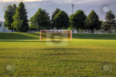 To use this stock image in your creative project, please select the size you need over to the right and click the "Add to Cart" button.
Your downloaded image will come with the Cutcaster watermark removed so don’t worry about the watermark you see on this page. Empty Pitch stock photo, An empty soccer goal with trees in the background. (HDR photo)
by Chris Hill